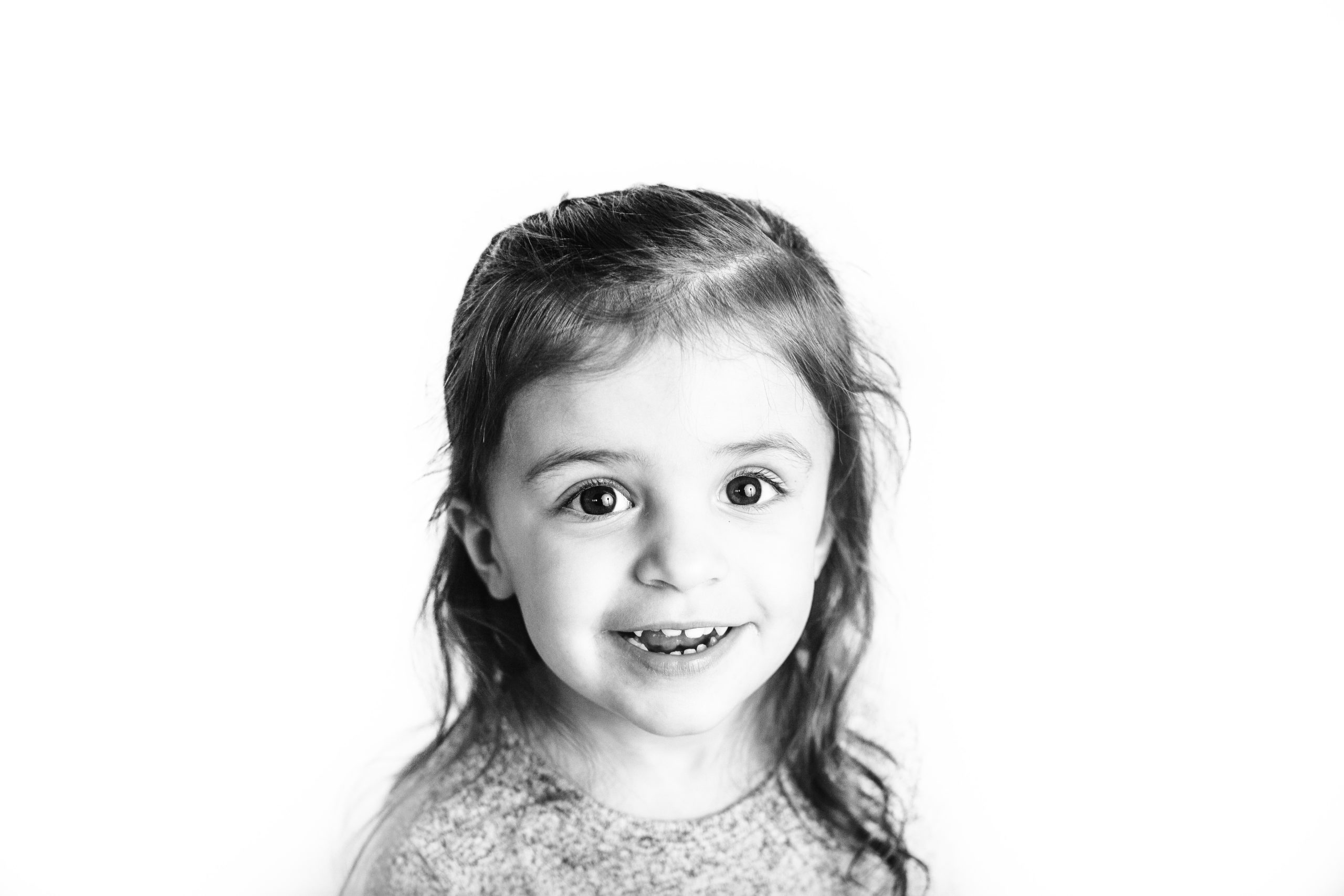 Image shows a young girl smiling during her expression session by Cedar Rapids Child Photographer Ali