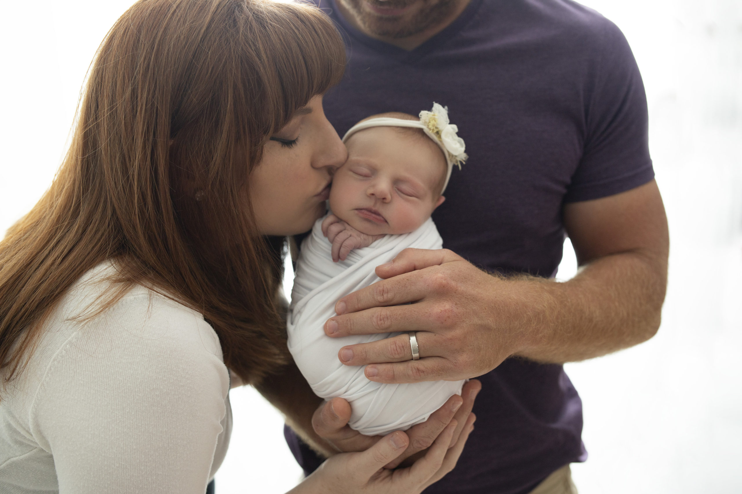 Cedar Rapids Mom kissing baby dad holding baby | Cedar Rapids Newborn Photographer