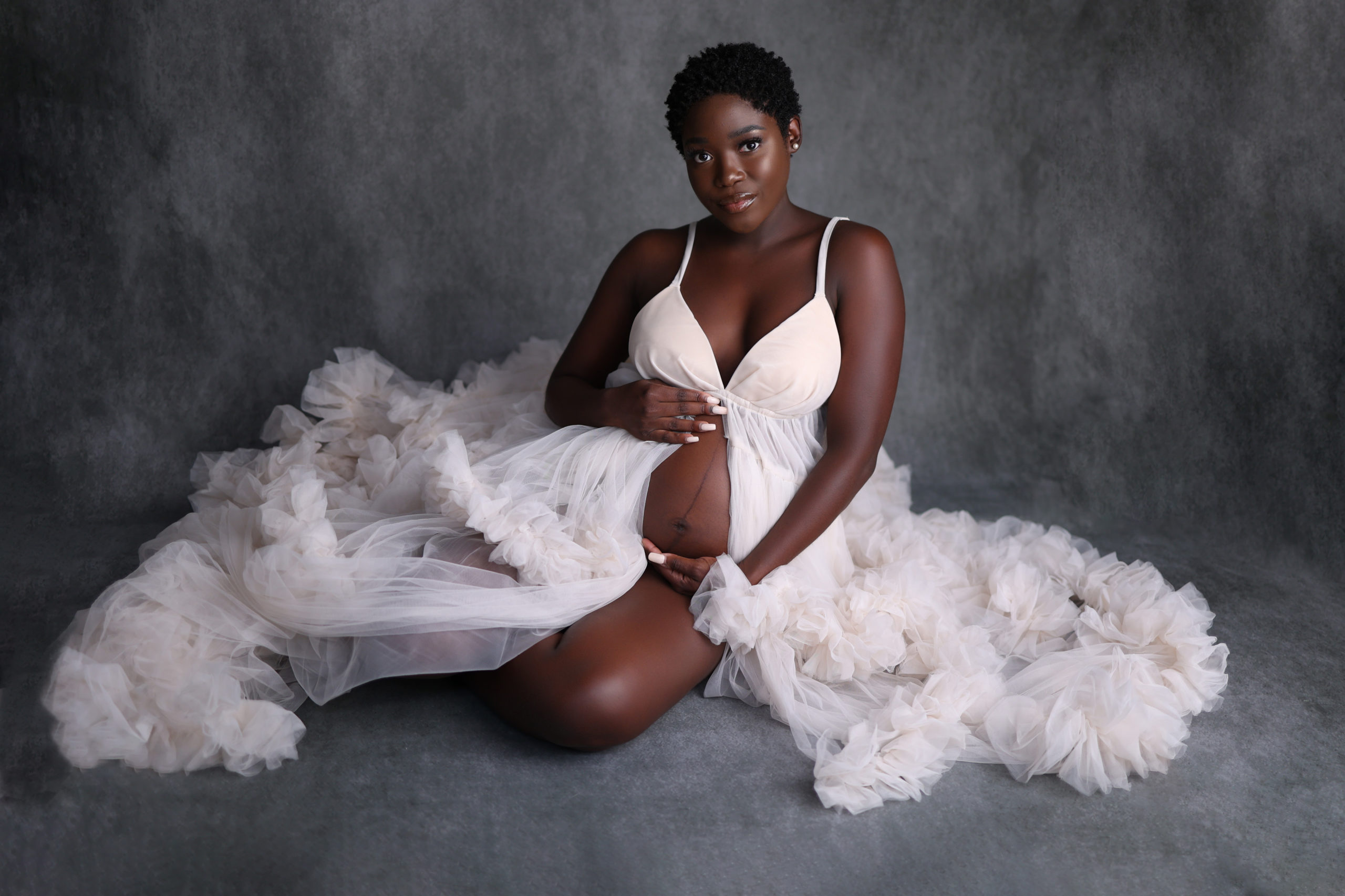 Cedar Rapids pregnant mother | Mother holding belly wearing a white dress